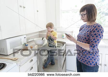 Mother and son standing in kitchen View Large Photo Image Stock Photograph - Mother and son standing in kitchen. Fotosearch
