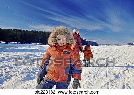 Mother and sons walking in snowy remote field View Large Photo Image Stock Image - Mother and sons walking in snowy remote field. Fotosearch