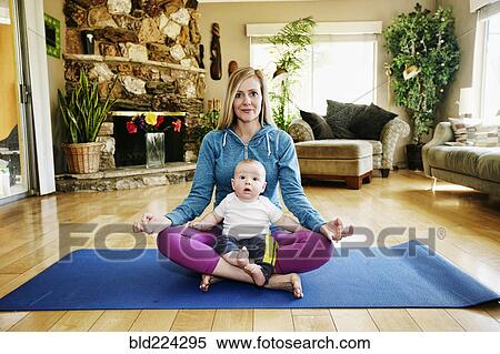 Mother meditating on exercise mat with baby in lap View Large Photo Image Stock Photography - Mother meditating on exercise mat with baby in lap. Fotosearch