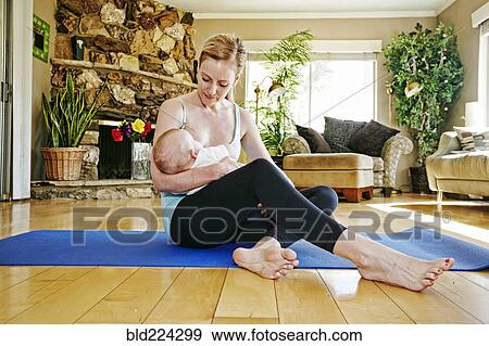 Mother resting from working out breastfeeding baby View Large Photo Image Stock Photo - Mother resting from working out breastfeeding baby. Fotosearch
