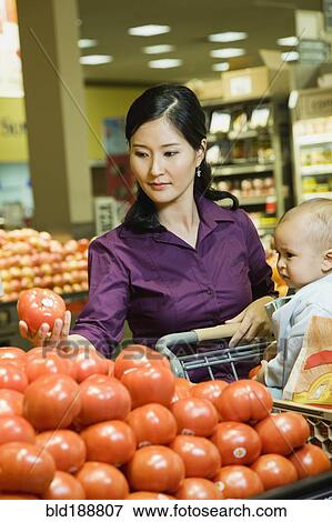 Mother shopping in grocery store with baby View Large Photo Image Stock Photo - Mother shopping in grocery store with baby. Fotosearch