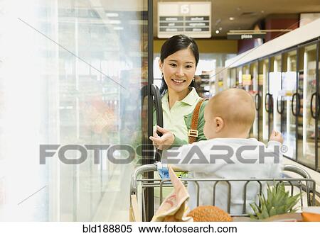 Mother shopping in grocery store with baby View Large Photo Image Stock Photography - Mother shopping in grocery store with baby. Fotosearch
