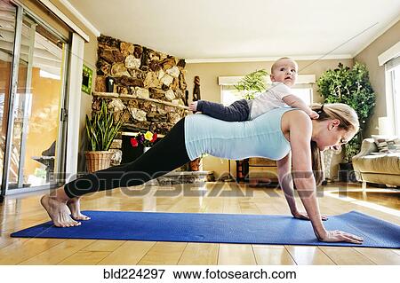 Mother working out on exercise mat with baby on back View Large Photo Image Stock Photo - Mother working out on exercise mat with baby on back. Fotosearch