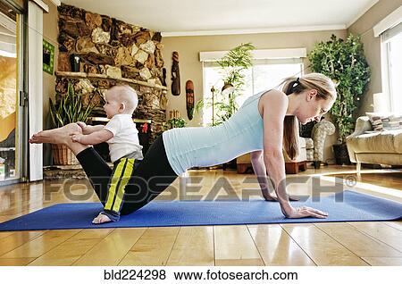 Mother working out on exercise mat with baby on legs View Large Photo Image Stock Photo - Mother working out on exercise mat with baby on legs. Fotosearch