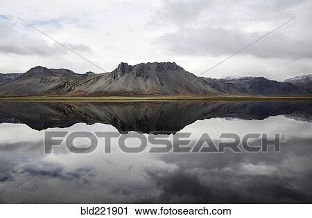Mountains reflecting in still lake View Large Photo Image Stock Image - Mountains reflecting in still lake. Fotosearch