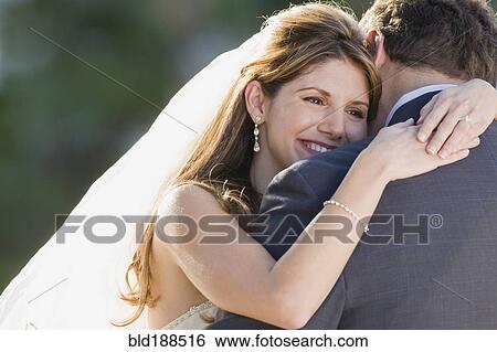 Stock Photograph - Multi-ethnic bride hugging father. Fotosearch