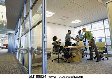 Multi-ethnic business people shaking hands in meeting View Large Photo Image Picture - Multi-ethnic business people shaking hands in meeting. Fotosearch
