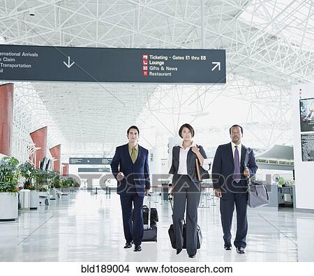 Picture - Multi-ethnic business people walking in airport. Fotosearch