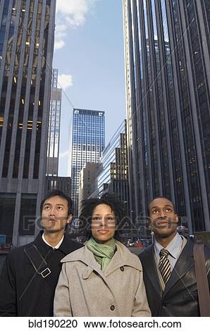 Stock Image - Multi-ethnic businesspeople in urban scene. Fotosearch