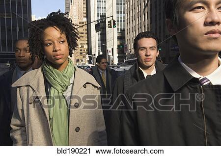 Stock Image - Multi-ethnic businesspeople in urban scene. Fotosearch
