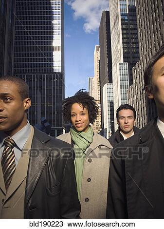 Stock Image - Multi-ethnic businesspeople in urban scene. Fotosearch