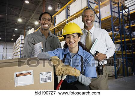 Multi-ethnic co-workers in warehouse View Large Photo Image Stock Photo - Multi-ethnic co-workers in warehouse. Fotosearch