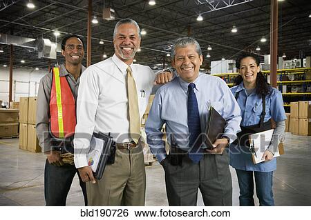 Stock Photograph - Multi-ethnic co-workers in warehouse. Fotosearch