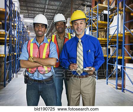 Stock Photography - Multi-ethnic co-workers in warehouse. Fotosearch