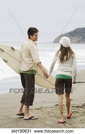 Multi-ethnic couple holding hands at beach View Large Photo Image Stock Image - Multi-ethnic couple holding hands at beach. Fotosearch