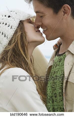 Stock Photograph - Multi-ethnic couple kissing. Fotosearch