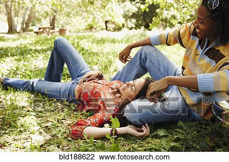Stock Image - Multi-ethnic couple relaxing outdoors. Fotosearch