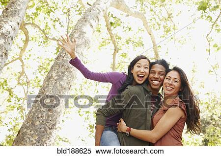 Stock Photography - Multi-ethnic friends laughing outdoors. Fotosearch