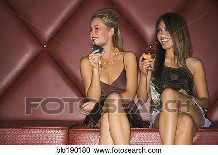 Stock Image - Multi-ethnic women holding cocktails. Fotosearch