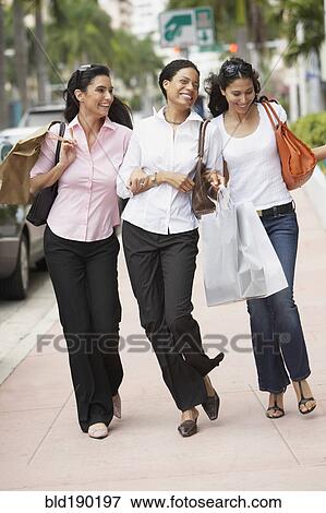 Stock Photo - Multi-ethnic women with shopping bags. Fotosearch