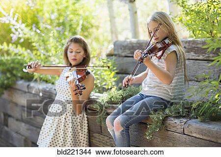 Picture - Musicians playing violins outdoors. Fotosearch