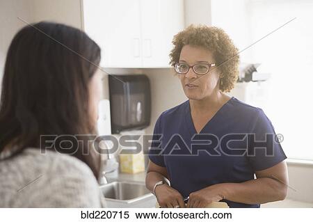 Stock Photography - Nurse talking to patient in hospital. Fotosearch
