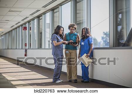 Stock Image - Nurses and doctor using digital tablet. Fotosearch