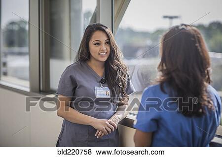Stock Photo - Nurses talking in hospital hallway. Fotosearch