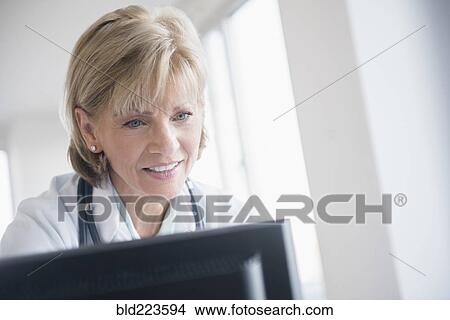 Older Caucasian doctor using computer View Large Photo Image Picture - Older Caucasian doctor using computer. Fotosearch