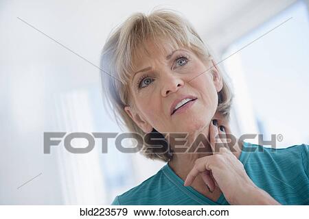 Stock Photo - Older Caucasian woman checking pulse on neck. Fotosearch