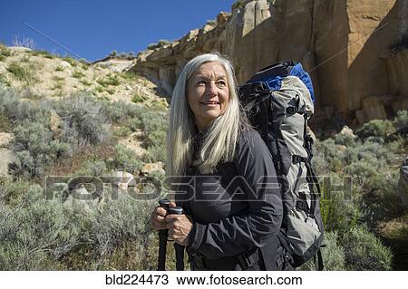 Stock Image - Older Caucasian woman hiking with backpack. Fotosearch