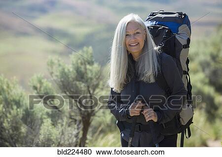 Stock Image - Older Caucasian woman hiking with backpack. Fotosearch