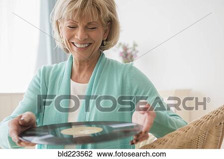 Older Caucasian woman holding vinyl record View Large Photo Image Stock Image - Older Caucasian woman holding vinyl record. Fotosearch