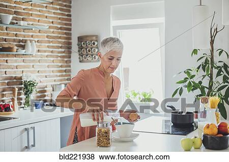 Older Caucasian woman pouring milk in kitchen View Large Photo Image Stock Photo - Older Caucasian woman pouring milk in kitchen. Fotosearch