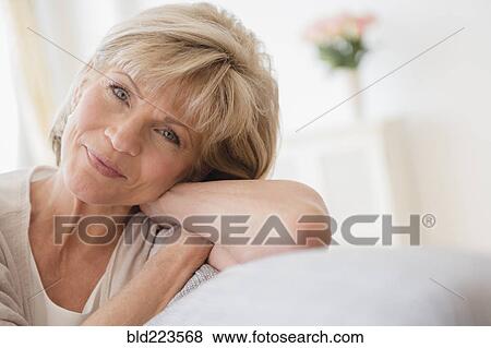 Stock Photo - Older Caucasian woman relaxing on sofa. Fotosearch