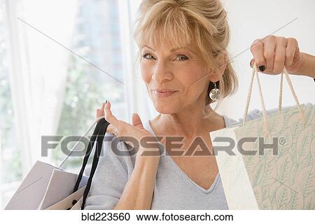 Older Caucasian woman showing shopping bags View Large Photo Image Stock Image - Older Caucasian woman showing shopping bags. Fotosearch