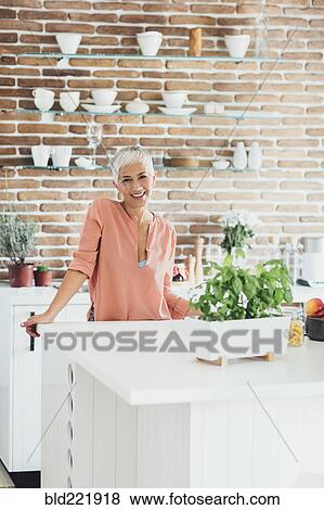 Stock Photo - Older Caucasian woman smiling in kitchen. Fotosearch