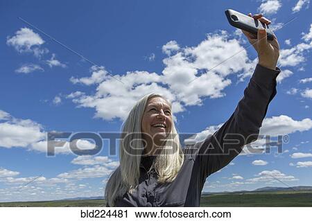 Stock Image - Older Caucasian woman taking selfie. Fotosearch