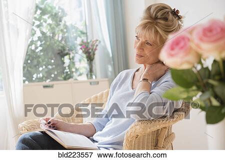 Stock Photo - Older Caucasian woman writing in journal. Fotosearch