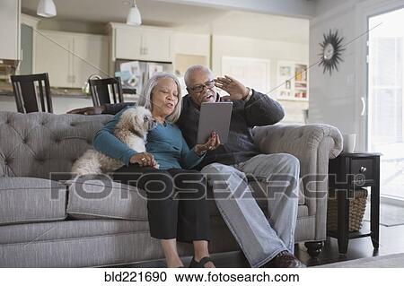 Stock Image - Older couple video chatting with digital tablet. Fotosearch