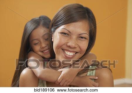 Stock Photograph - Pacific Islander mother and daughter hugging. Fotosearch
