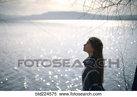 Pensive Caucasian girl at lake looking up View Large Photo Image Stock Photography - Pensive Caucasian girl at lake looking up. Fotosearch
