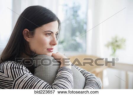 Stock Photo - Pensive Caucasian woman clutching pillow. Fotosearch