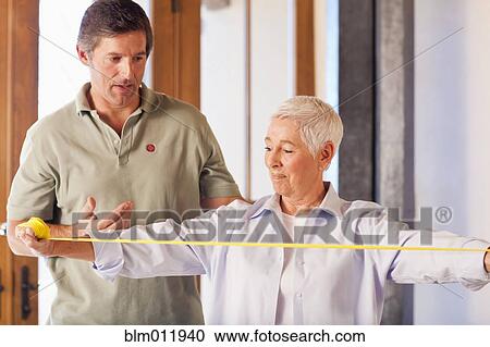 Physical therapist helping woman with exercises View Large Photo Image Stock Image - Physical therapist helping woman with exercises. Fotosearch