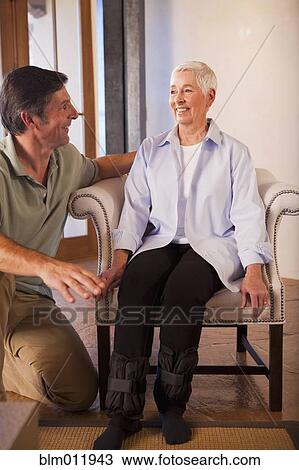 Stock Image - Physical therapist helping woman with exercises. Fotosearch