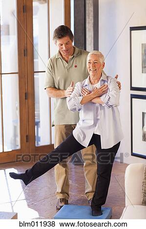 Stock Photo - Physical therapist helping woman with exercises. Fotosearch