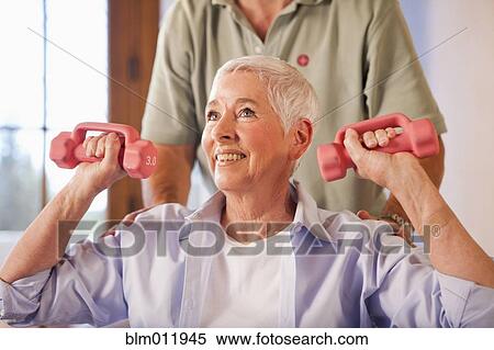 Stock Photography - Physical therapist helping woman with exercises. Fotosearch