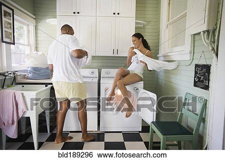 Stock Photograph - Playful couple folding laundry. Fotosearch