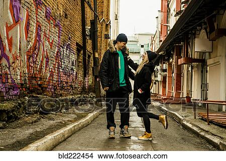Picture - Playful couple in urban alley. Fotosearch
