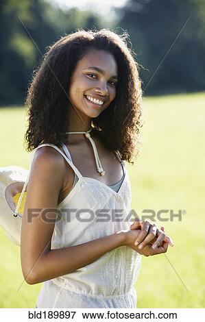 Stock Photo - Portrait of African woman standing in meadow. Fotosearch